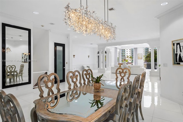 dining space featuring decorative columns, ornamental molding, and light tile patterned flooring