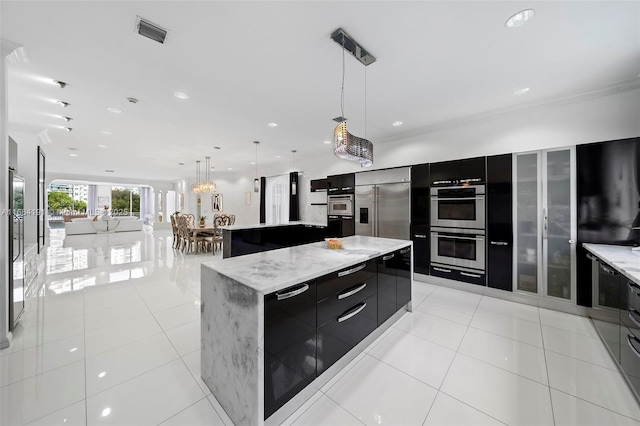 kitchen featuring appliances with stainless steel finishes, decorative light fixtures, a large island, and modern cabinets