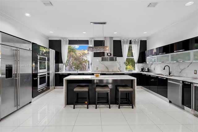 kitchen with visible vents, a center island, hanging light fixtures, stainless steel appliances, and backsplash