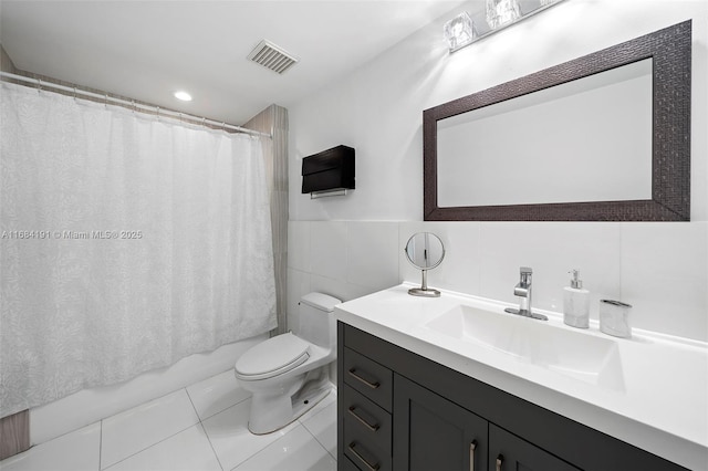 full bathroom featuring toilet, vanity, visible vents, tile walls, and tile patterned floors