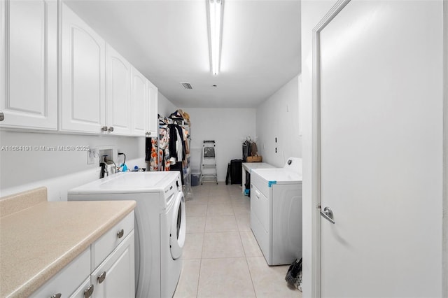 laundry room with cabinet space, independent washer and dryer, visible vents, and light tile patterned floors