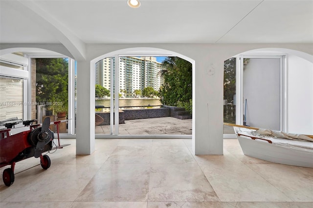 doorway with a wall unit AC, a view of city, and recessed lighting