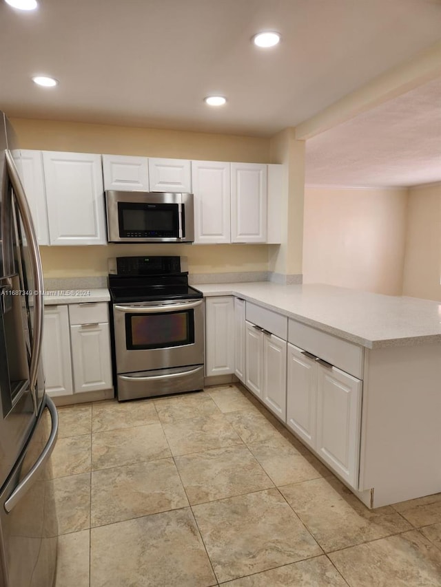 kitchen featuring appliances with stainless steel finishes, kitchen peninsula, and white cabinets