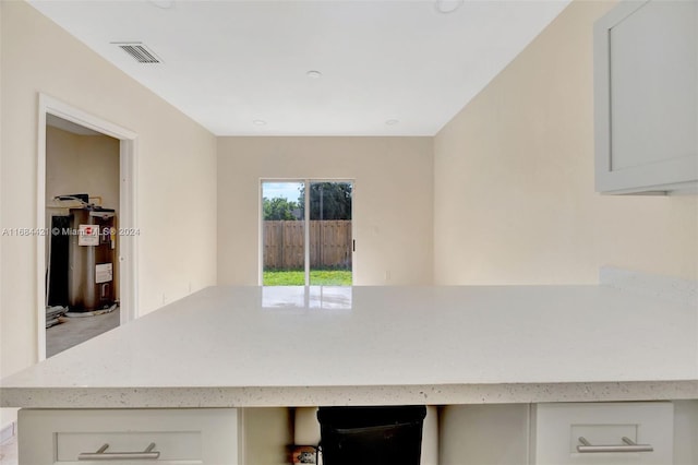 kitchen with electric water heater and white cabinets