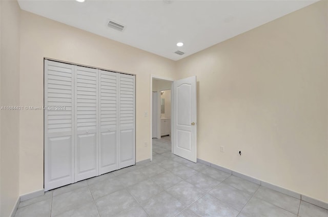 unfurnished bedroom featuring light tile patterned floors and a closet