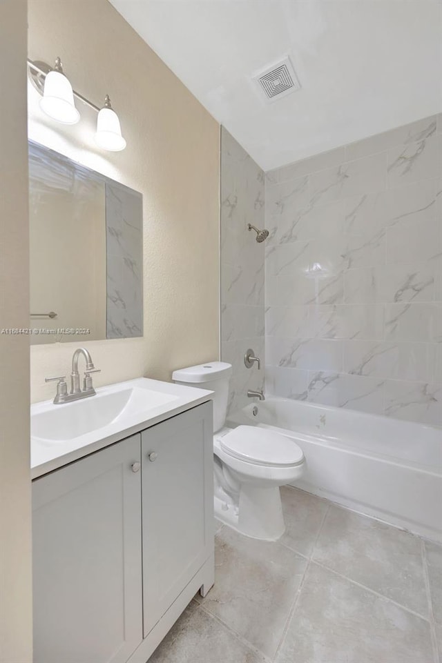 full bathroom featuring tile patterned flooring, vanity, toilet, and tiled shower / bath combo