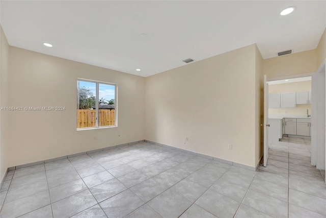 empty room featuring light tile patterned floors and sink