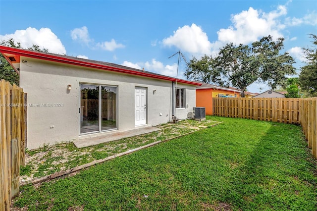 back of house featuring a yard and cooling unit