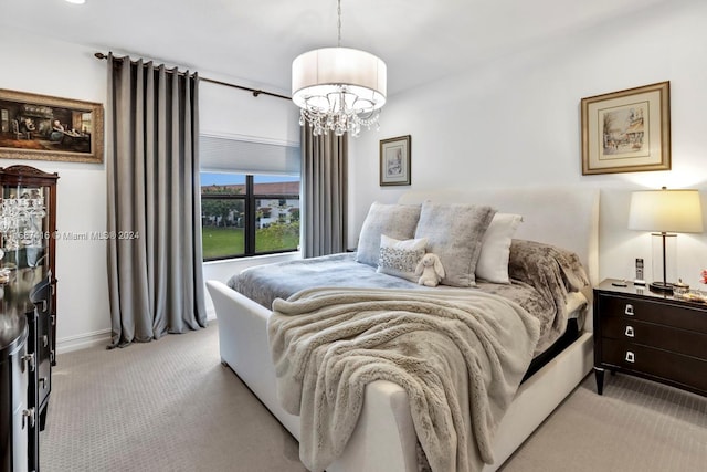 bedroom featuring light carpet and an inviting chandelier