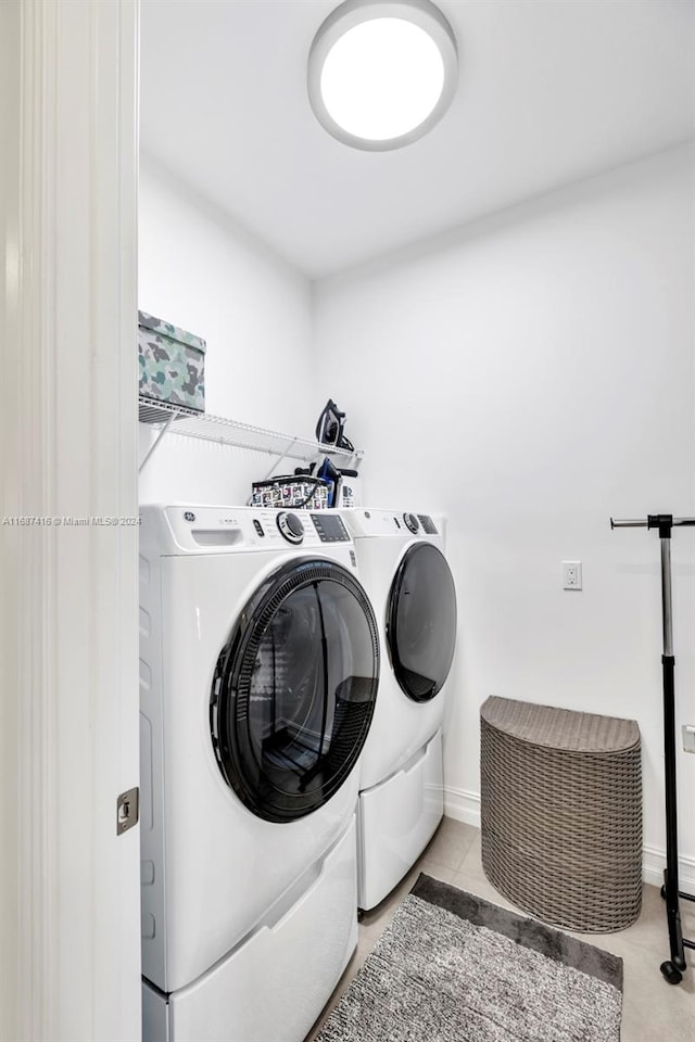 washroom featuring light tile patterned flooring and washing machine and clothes dryer