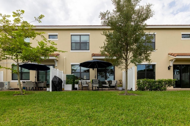 back of property with a yard and a patio area