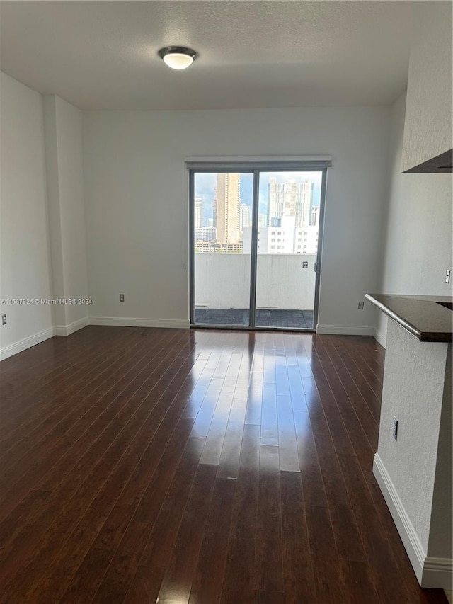 empty room with dark hardwood / wood-style flooring