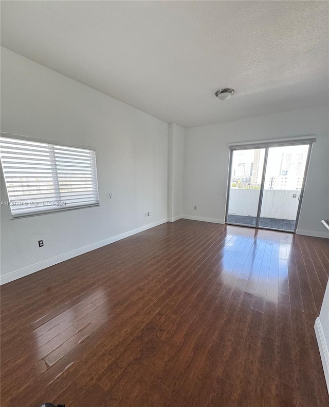 empty room featuring dark hardwood / wood-style floors and a textured ceiling