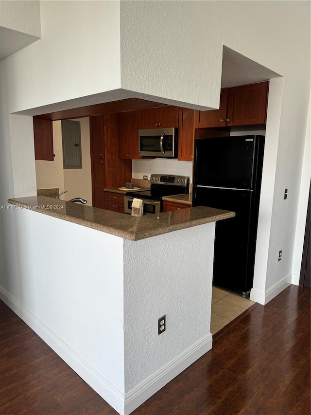 kitchen with hardwood / wood-style flooring, appliances with stainless steel finishes, electric panel, and kitchen peninsula