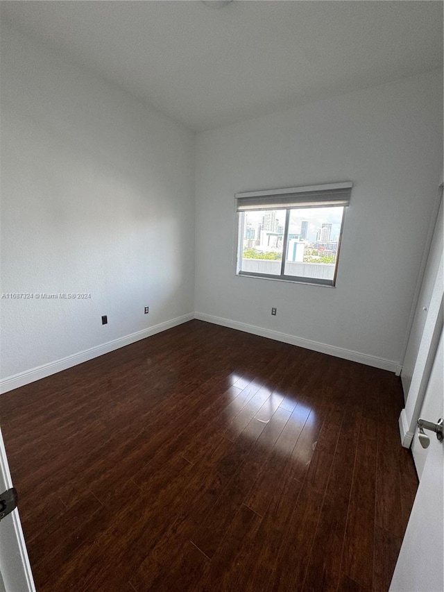 unfurnished room featuring dark wood-type flooring