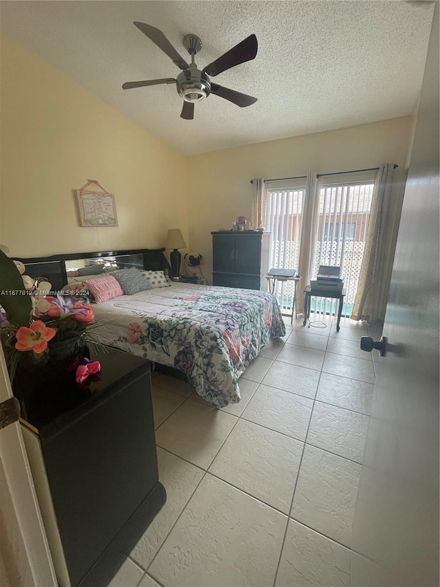 tiled bedroom featuring a textured ceiling and ceiling fan