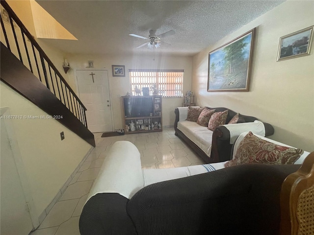 tiled living room featuring ceiling fan and a textured ceiling