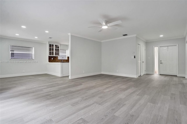 unfurnished living room with light hardwood / wood-style flooring, ceiling fan, ornamental molding, and sink