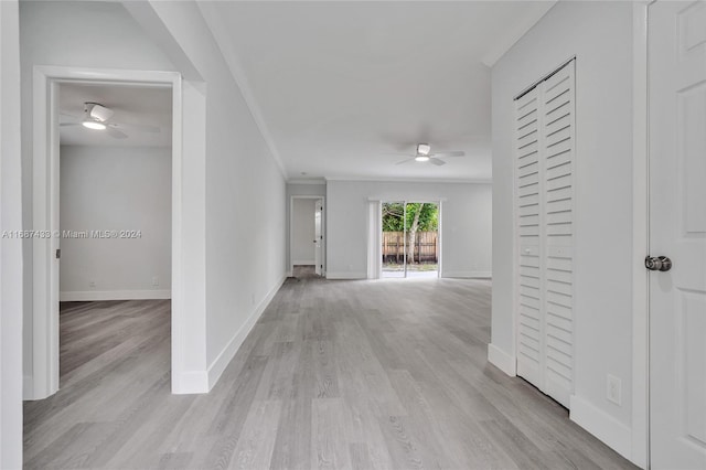 hall with light hardwood / wood-style floors and crown molding