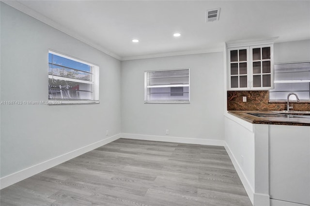 kitchen featuring light hardwood / wood-style floors, ornamental molding, and sink