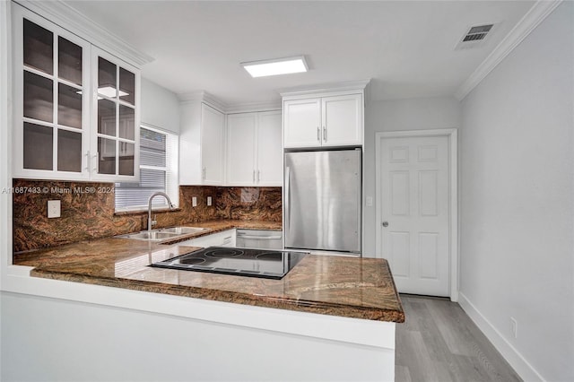 kitchen with kitchen peninsula, stainless steel appliances, white cabinets, and sink