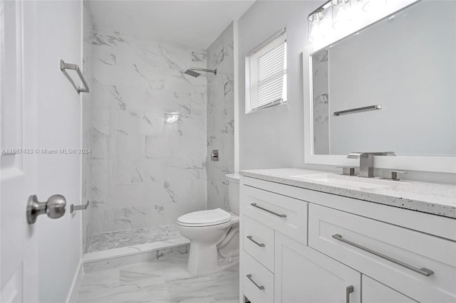 bathroom featuring vanity, toilet, and a tile shower