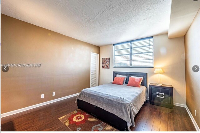 bedroom with dark wood-type flooring and a textured ceiling