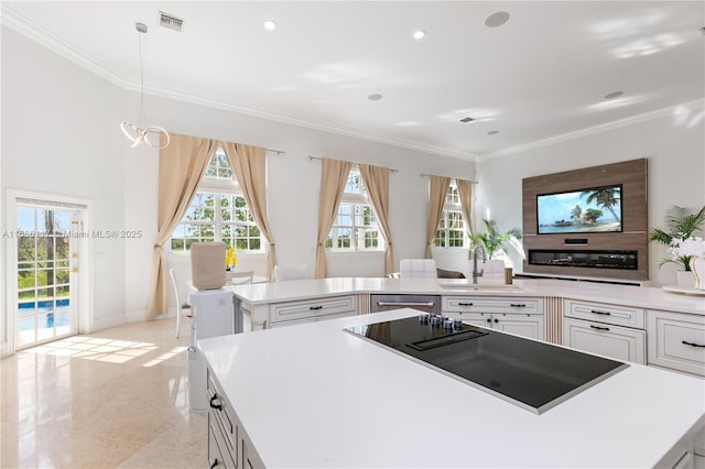 kitchen featuring ornamental molding, visible vents, a kitchen island, and black electric stovetop