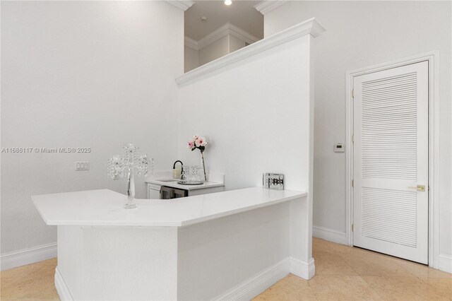 bar with crown molding, light tile patterned flooring, a sink, and baseboards