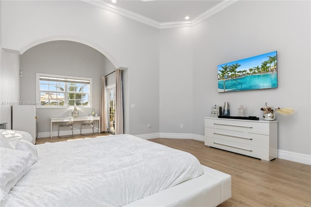 bedroom with arched walkways, recessed lighting, wood finished floors, baseboards, and ornamental molding