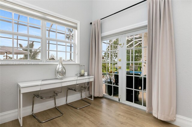 home office with light wood-style flooring, baseboards, and french doors