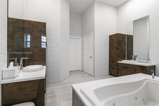 full bathroom with tile patterned floors, a tub with jets, and vanity