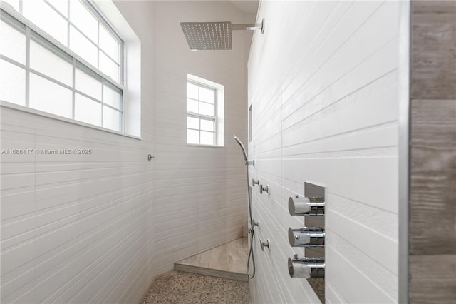 full bath with speckled floor and a tile shower