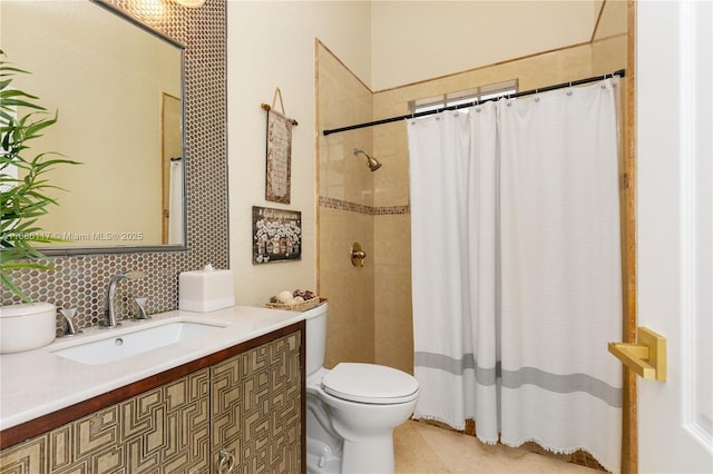 bathroom with a tile shower, vanity, and toilet