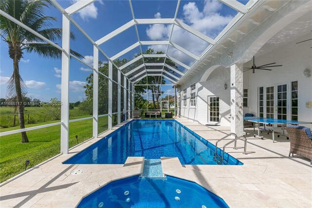 view of swimming pool featuring a lanai, a patio area, ceiling fan, and a lawn