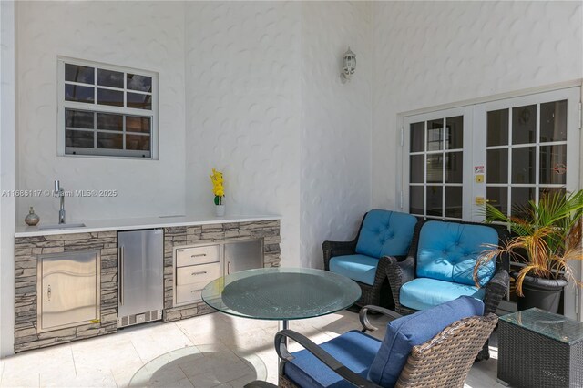 view of patio featuring french doors, outdoor dining area, area for grilling, and a sink