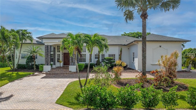 view of front facade with a front yard and stucco siding