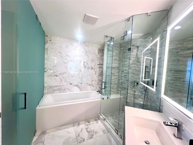 bathroom with vanity and shower with separate bathtub