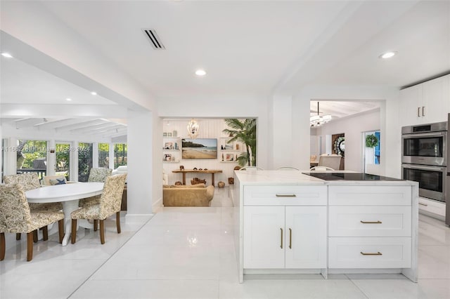 kitchen with light tile patterned floors, white cabinetry, a notable chandelier, black electric stovetop, and stainless steel double oven