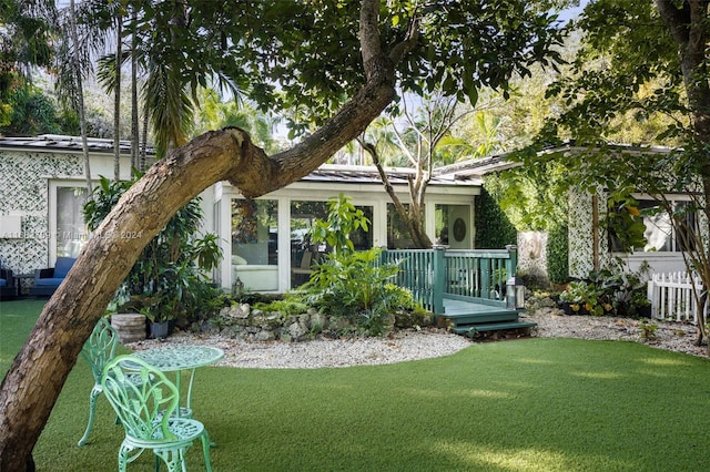 rear view of house featuring a yard and a deck