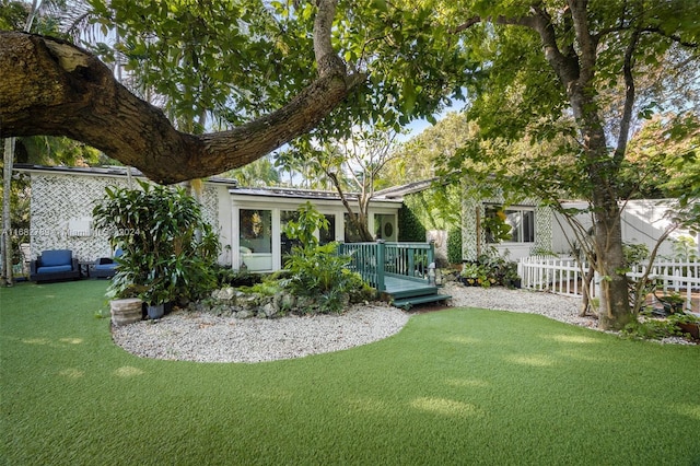 rear view of property with a yard and a deck