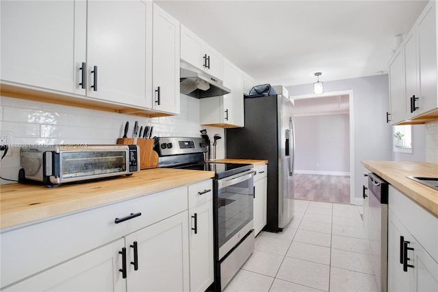 kitchen featuring stainless steel appliances, wood counters, and white cabinets