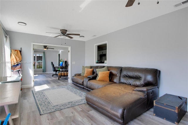 living room featuring ceiling fan and hardwood / wood-style flooring