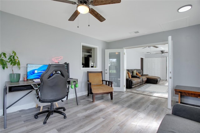 office with light hardwood / wood-style floors and ceiling fan