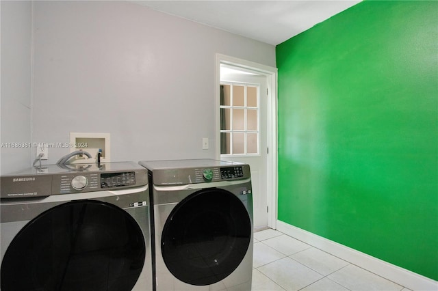 laundry room with washer and dryer and light tile patterned floors