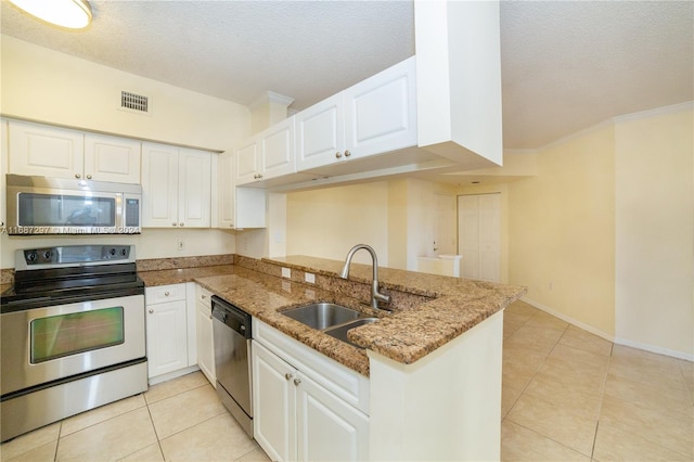 kitchen featuring kitchen peninsula, stainless steel appliances, sink, white cabinetry, and a textured ceiling