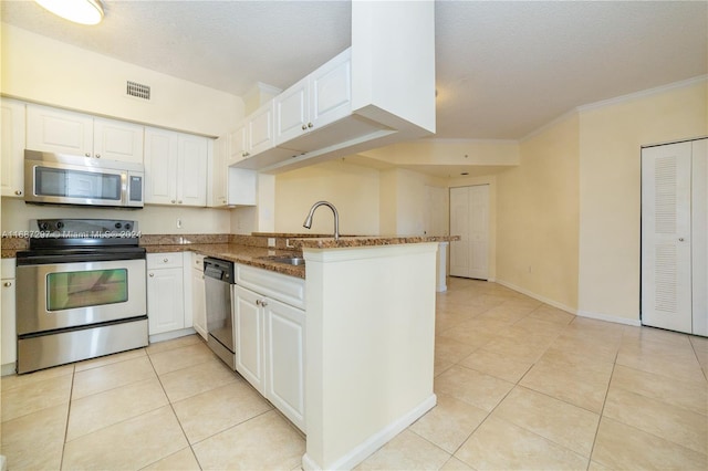 kitchen featuring appliances with stainless steel finishes, kitchen peninsula, white cabinets, and sink