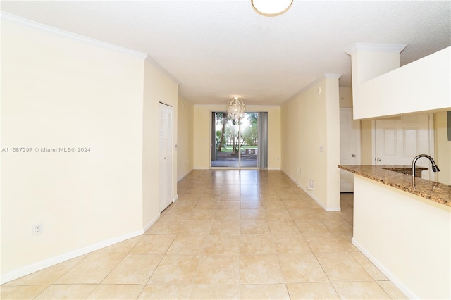 interior space featuring crown molding, light stone countertops, a textured ceiling, and light tile patterned floors