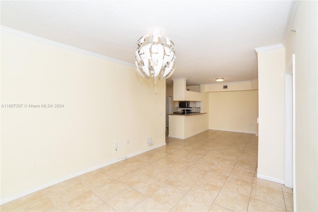 empty room featuring light tile patterned flooring, ornamental molding, a chandelier, and a textured ceiling