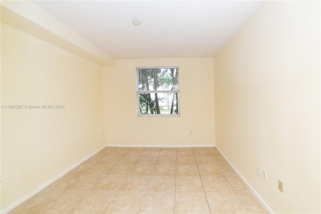 empty room featuring a textured ceiling and light tile patterned floors